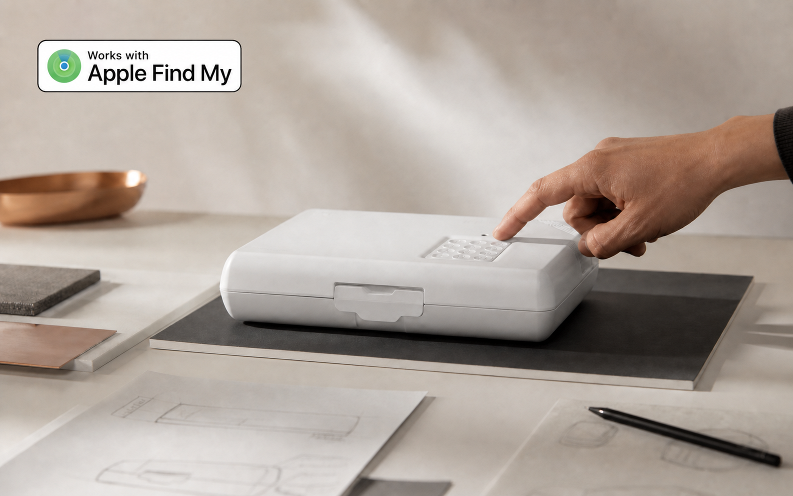 Une main teste le clavier du coffre nomade UpLock sur une table de développement produit.